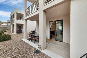 Entrance to property with outdoor dining space, a patio area, and stucco siding