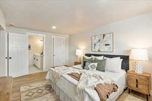 Bedroom with recessed lighting, light wood-style flooring, and ensuite bathroom