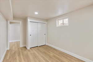 Unfurnished bedroom featuring recessed lighting, a closet, light wood-type flooring, and baseboards