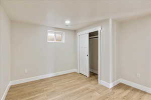 Unfurnished bedroom with light wood finished floors, a closet, visible vents, and baseboards