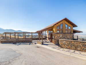 Exterior space with stone siding, a mountain view, and fence