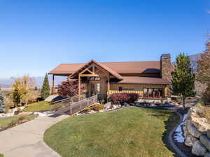 View of front of home featuring a chimney, a front lawn, and board and batten siding