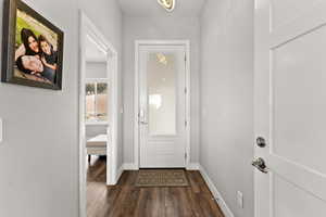 Doorway to outside featuring dark wood finished floors and baseboards