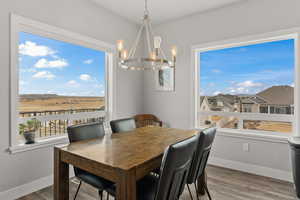 Dining space with an inviting chandelier, baseboards, and wood finished floors
