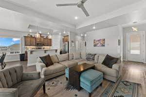 Living room with baseboards, ceiling fan, dark wood-type flooring, and recessed lighting