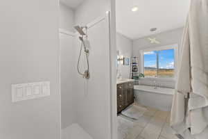 Full bath with walk in shower, tile patterned flooring, a freestanding tub, and vanity