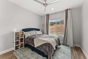 Bedroom featuring ceiling fan, baseboards, and wood finished floors