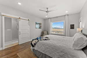 Bedroom featuring recessed lighting, dark wood finished floors, baseboards, and a barn door