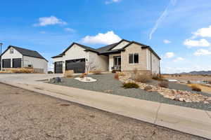 View of front of house with a garage, concrete driveway, brick siding, and a mountain view
