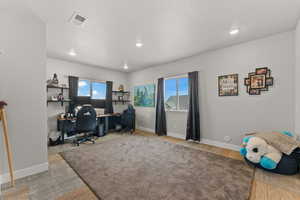 Office with baseboards, visible vents, and a healthy amount of sunlight