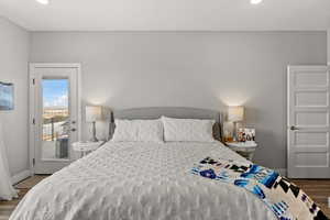 Bedroom featuring dark wood-style floors, access to outside, recessed lighting, and baseboards