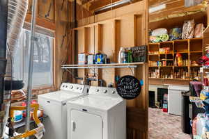 Laundry room featuring a wealth of natural light and washing machine and clothes dryer