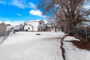 Snow covered property featuring stairs, fence, and a residential view