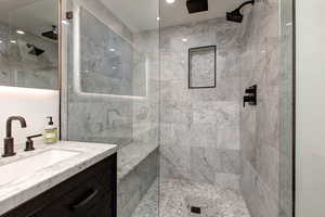 Main bathroom featuring a tile shower and vanity