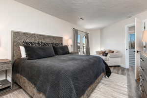 Main bedroom with french doors to the deck and wood finished floors