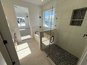 Bathroom with tile patterned floors, vanity, a shower stall, a wealth of natural light, and a bath