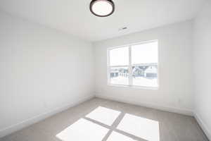Empty room featuring light carpet and baseboards