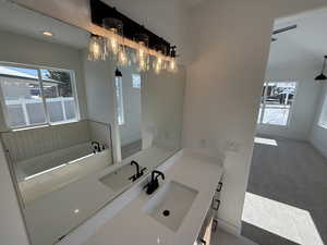 Full bathroom with baseboards, a bath, and vanity