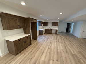 Kitchen with light countertops, light wood-style flooring, visible vents, and baseboards