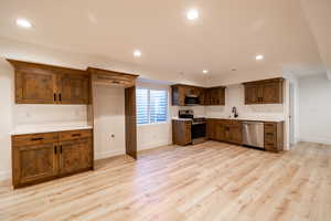Kitchen featuring stainless steel appliances, recessed lighting, light wood-type flooring, and light countertops