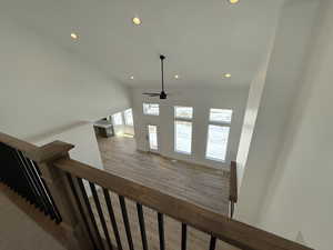 Staircase with wood finished floors and recessed lighting