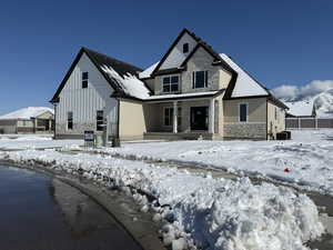 View of front facade with stone siding and board and batten siding