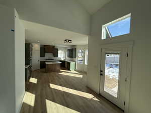 Interior space featuring a center island, light countertops, dark brown cabinetry, light wood-type flooring, and baseboards