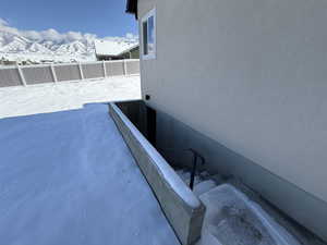 Details featuring fence, a mountain view, and stucco siding