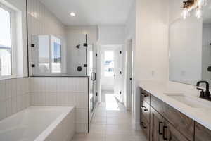 Bathroom with a garden tub, vanity, a shower stall, tile patterned floors, and recessed lighting