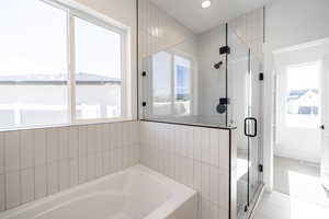 Full bath featuring a bath, a shower stall, and recessed lighting