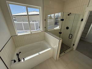 Bathroom featuring a stall shower, a bath, and tile patterned floors