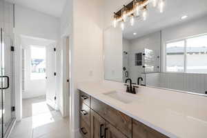 Bathroom featuring vanity, a stall shower, tile patterned floors, and recessed lighting