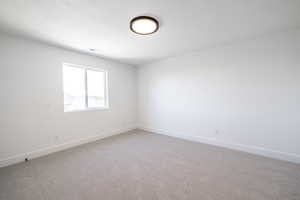 Unfurnished room featuring light colored carpet and baseboards