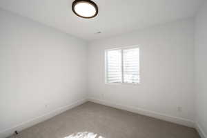 Spare room with light colored carpet and baseboards
