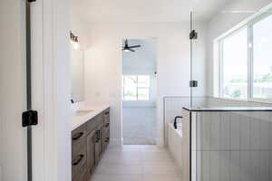 Bathroom with vanity, a ceiling fan, a bath, and tile patterned floors