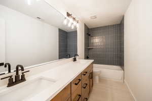 Full bathroom featuring double vanity, tub / shower combination, and tile patterned floors