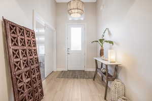 Foyer featuring a wealth of natural light, light wood-type flooring, and baseboards