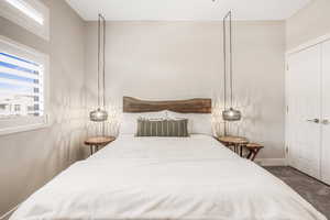 Bedroom featuring dark carpet and baseboards