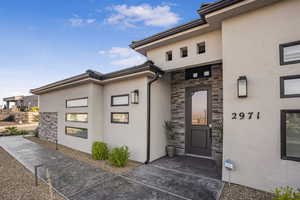 View of exterior entry with stone siding and stucco siding