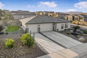 View of front of property featuring driveway, a tile roof, a residential view, an attached garage, and fence