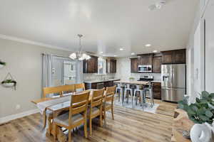 Dining space featuring light wood-style flooring, recessed lighting, visible vents, baseboards, and an inviting chandelier