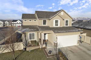 Traditional-style house featuring roof with shingles, fence, and stucco siding