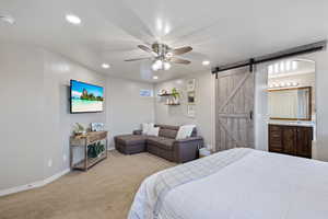 Bedroom featuring a barn door, recessed lighting, and light colored carpet