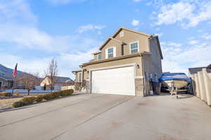 View of front of property with an attached garage, driveway, fence, and stucco siding