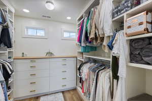 Spacious closet featuring light wood-style floors and visible vents