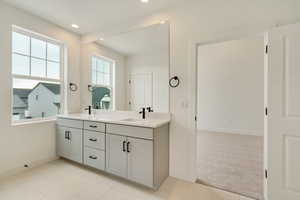 Full bath featuring recessed lighting, a sink, baseboards, and double vanity