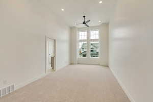 Empty room with recessed lighting, light carpet, visible vents, a ceiling fan, and baseboards