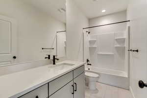 Full bathroom with tub / shower combination, vanity, toilet, and tile patterned floors