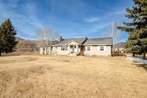 Single story home with a front yard and a mountain view