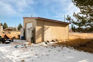 Snow covered structure featuring an outdoor structure